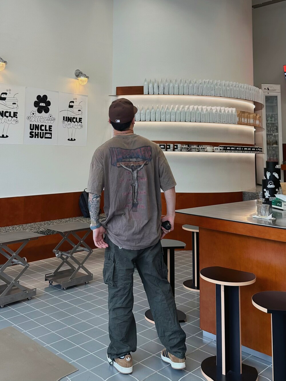 ブラウン系のTシャツ/カットソー、グリーン系のチノパンツ、グレー系のスニーカーを着用したメンズの春コーディネートの3枚目の写真