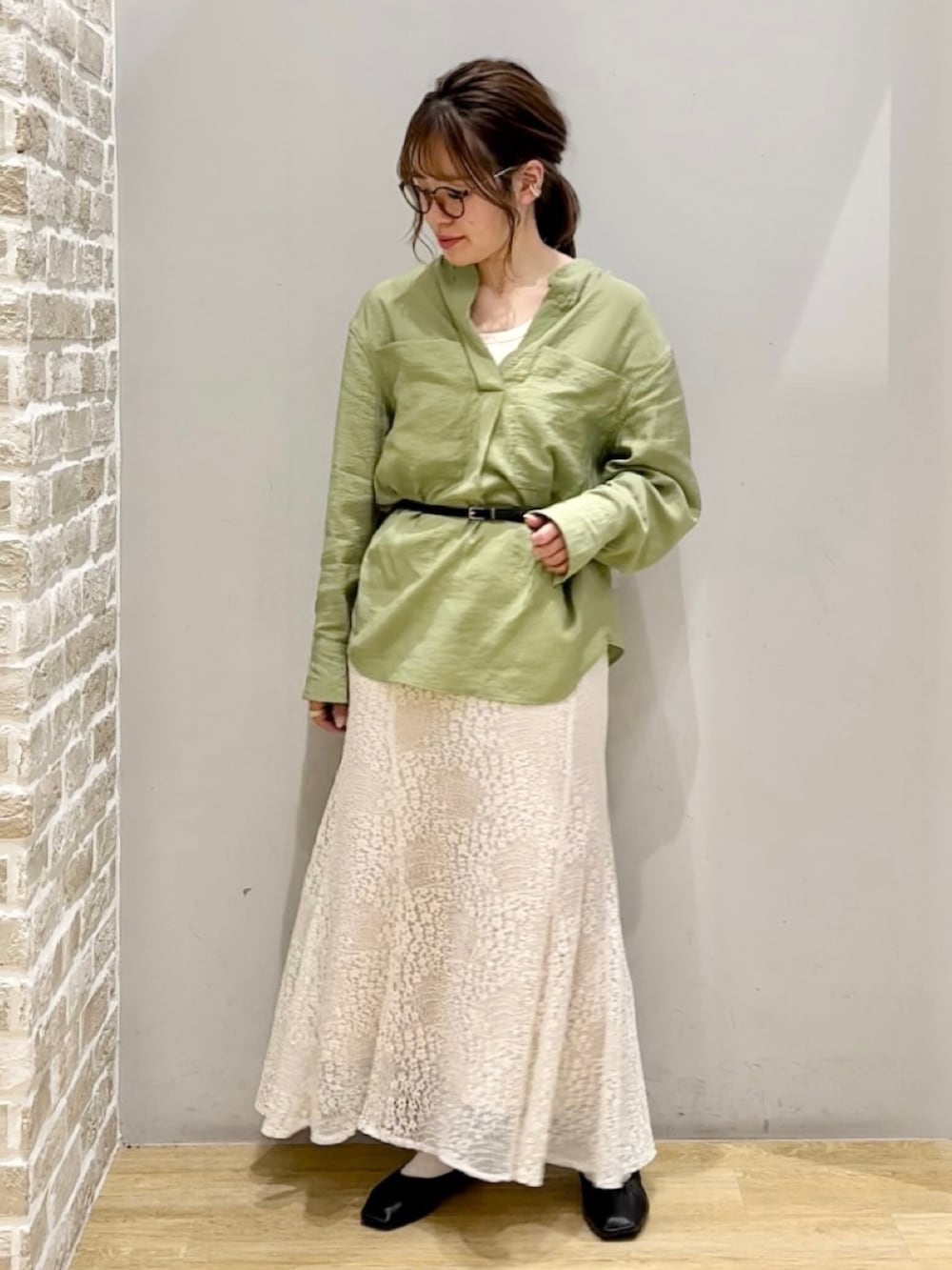 ブラック系のシューズ、ホワイト系のスカート、グリーン系のシャツ/ブラウスを着用したレディースの春コーディネートの2枚目の写真