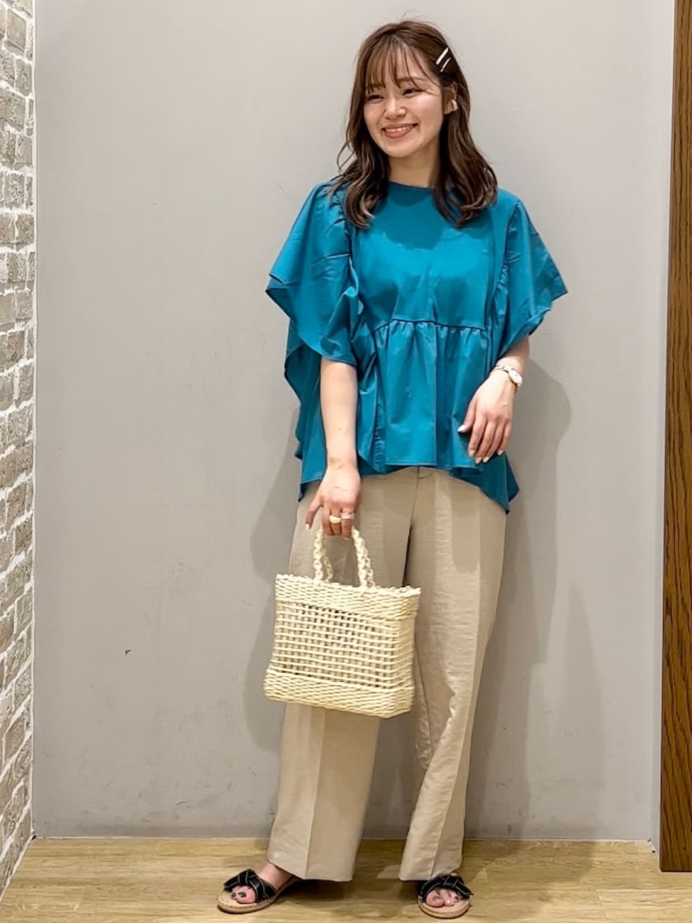 ベージュ系のその他パンツ、ブルー系のTシャツ/カットソー、ブラック系のサンダルを着用したレディースの夏コーディネートの2枚目の写真