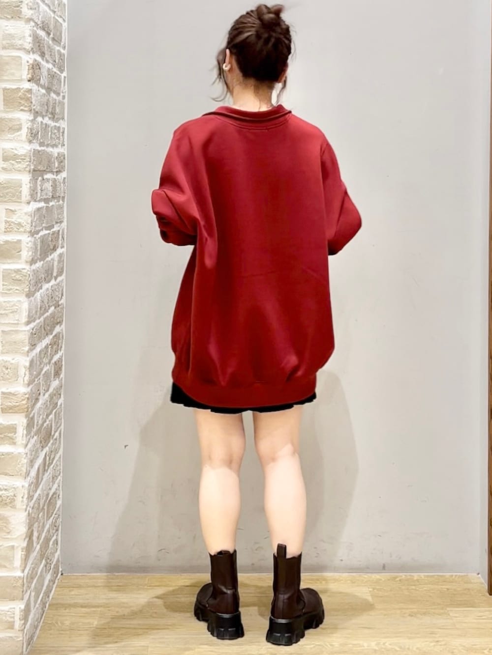 レッド系のスウェット、ブラック系のスカートを着用したレディースの秋コーディネートの2枚目の写真