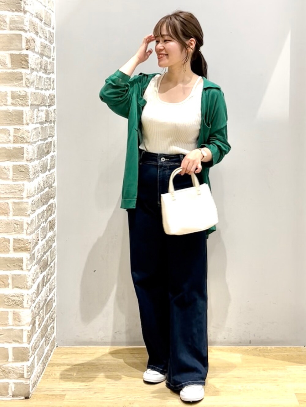 ブルー系のデニムパンツ、グリーン系のシャツ/ブラウス、ホワイト系のタンクトップを着用したレディースの夏コーディネートの2枚目の写真