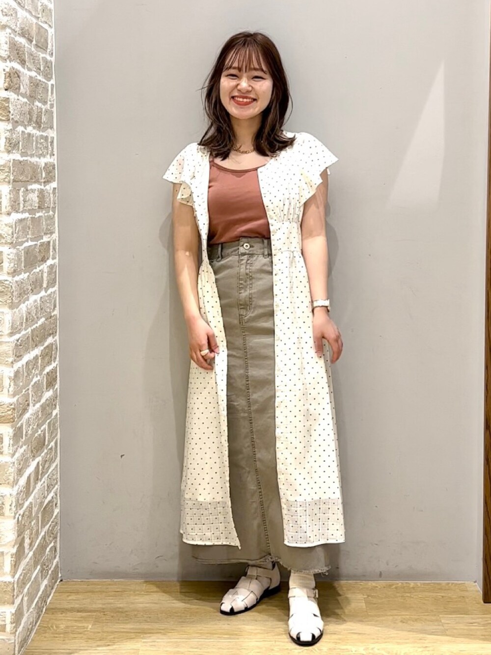 ブルー系のシューズ、グレー系のデニムスカート、ブラウン系のタンクトップを着用したレディースの夏コーディネートの2枚目の写真