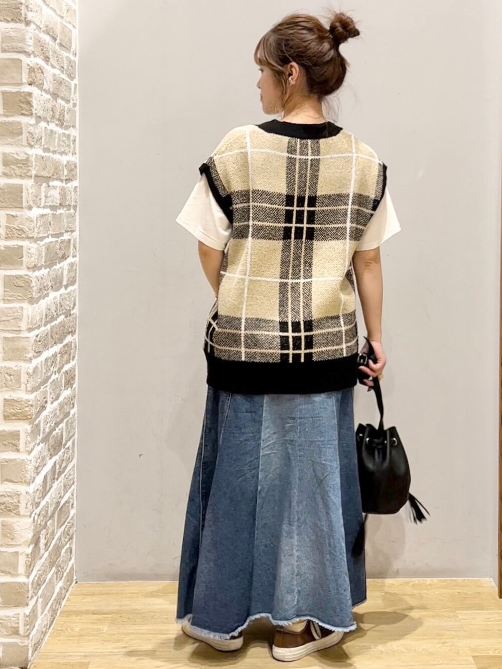 ブルー系のスカート、ブラック系のショルダーバッグ、ホワイト系のTシャツ/カットソーを着用したレディースの秋コーディネートの2枚目の写真