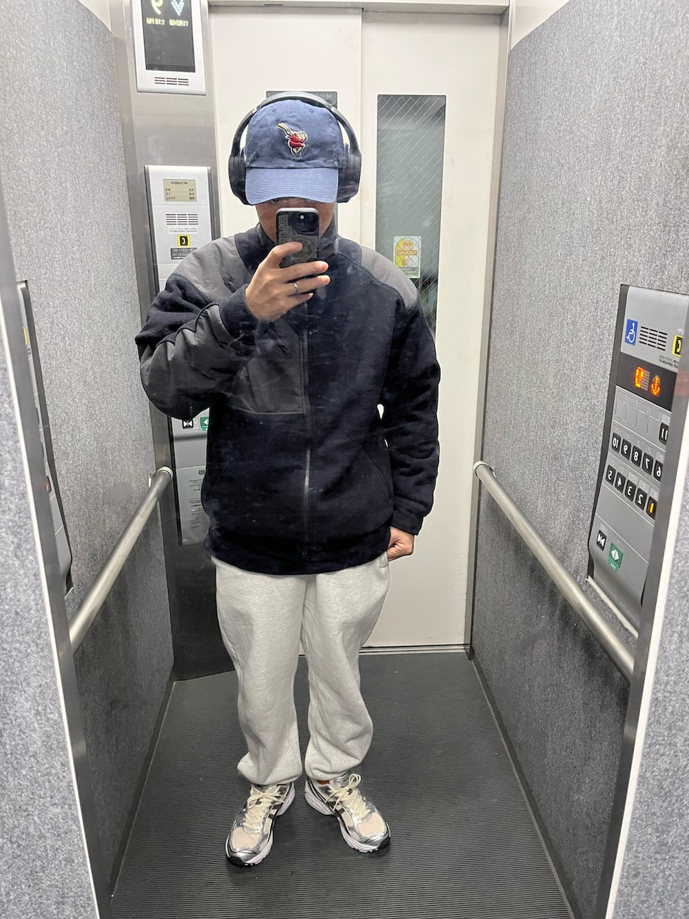 ブラック系のパンツ、ブラック系のその他シューズ、ブルー系のマウンテンパーカーを着用したメンズの秋コーディネートの3枚目の写真