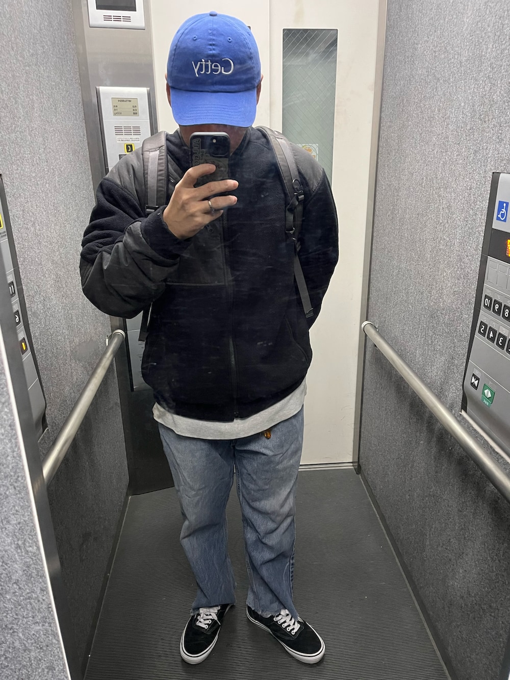 ブラック系のパンツ、ブラック系のその他シューズ、ブルー系のマウンテンパーカーを着用したメンズの秋コーディネートの2枚目の写真