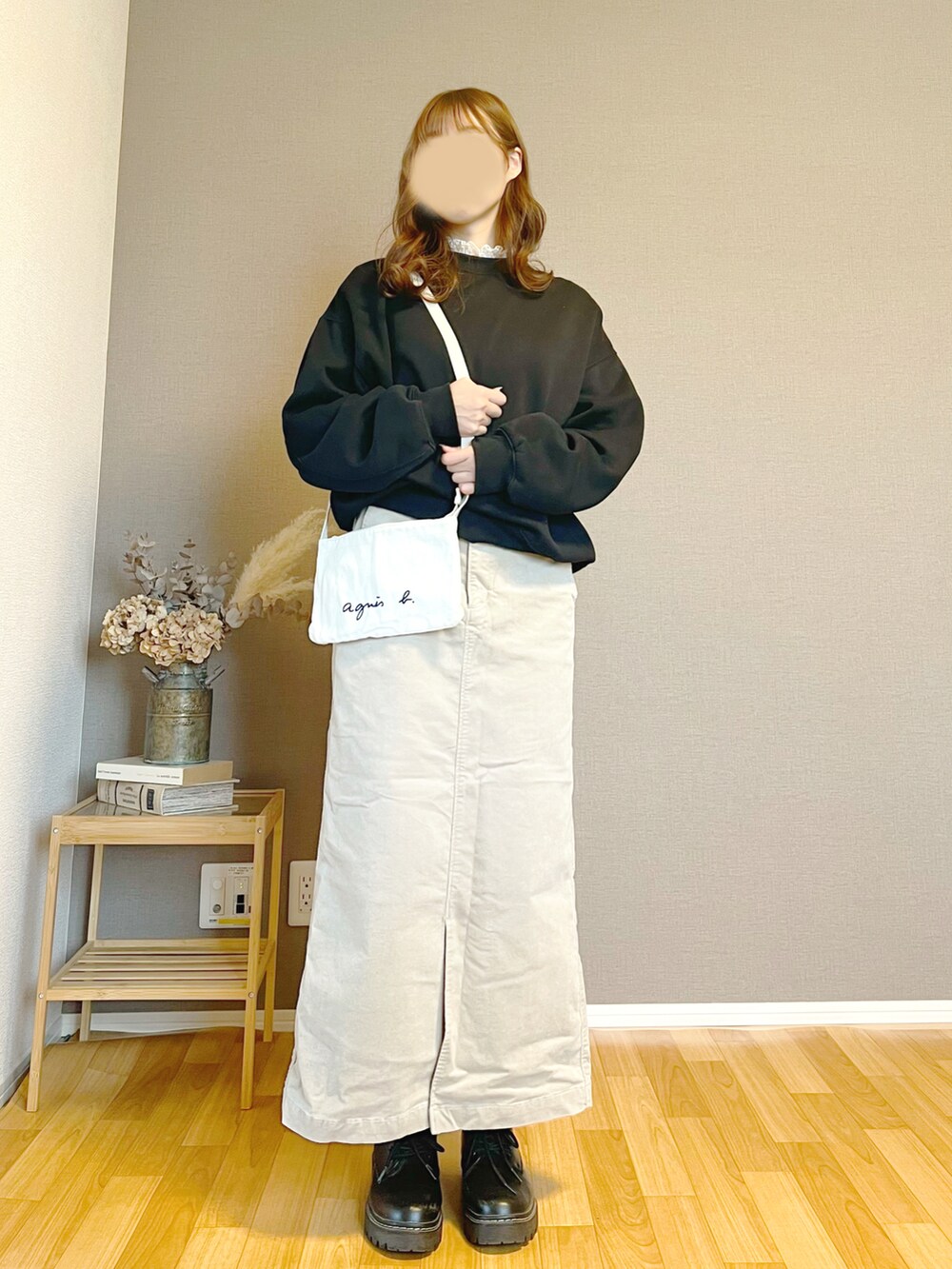 ベージュ系のスカート、ブラック系のスウェットを着用したレディースの秋コーディネートの2枚目の写真