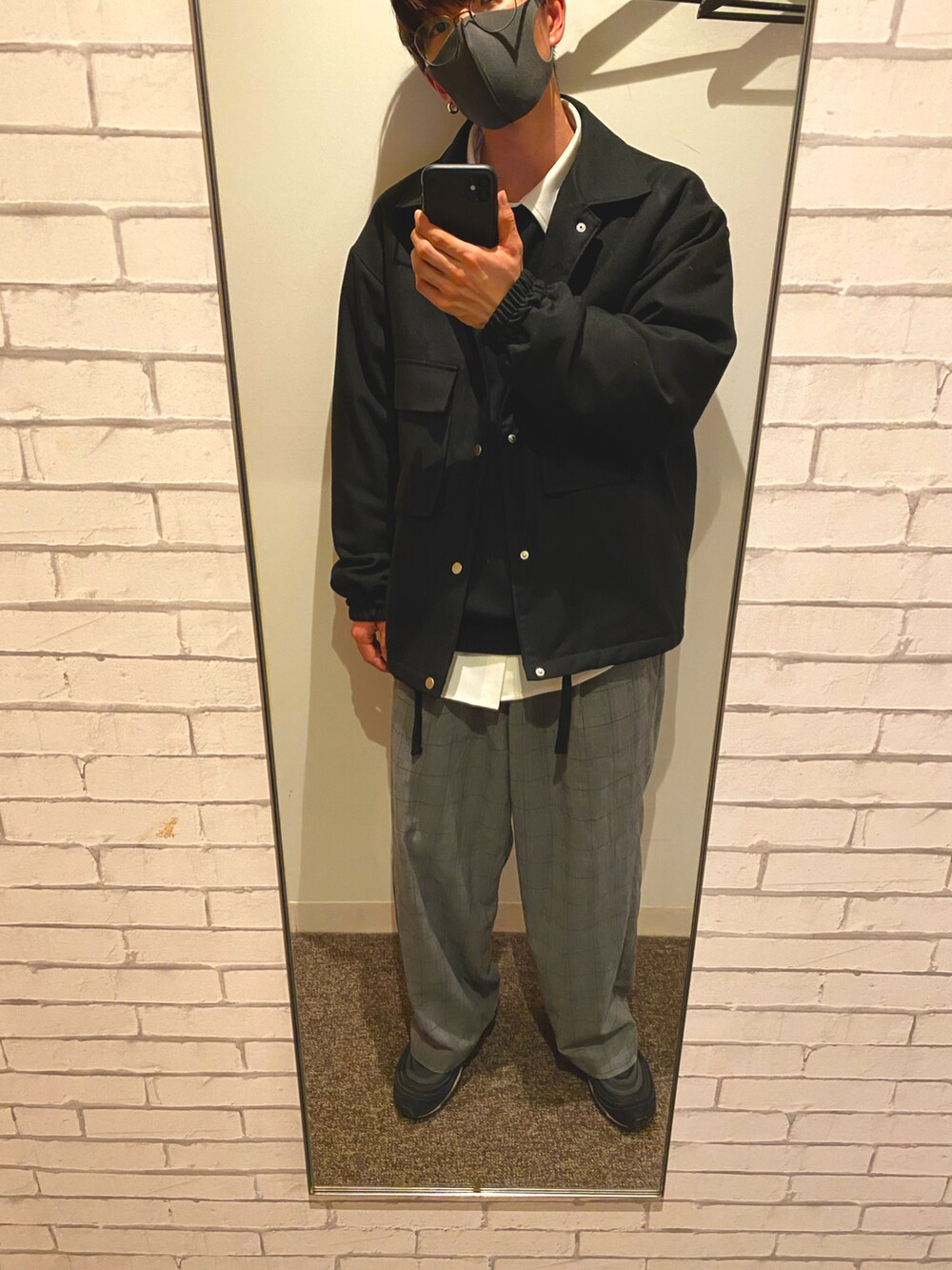 ブラック系のスウェット、グレー系のスラックス、ホワイト系のシャツ/ブラウスを着用したメンズの冬コーディネートの2枚目の写真