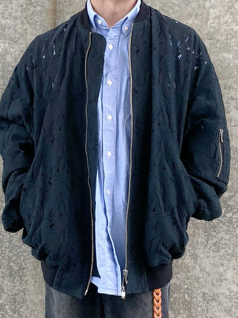 ブラック系のデニムパンツ、ベージュ系のスニーカー、ブラック系のブルゾンを着用したメンズの春コーディネートの3枚目の写真