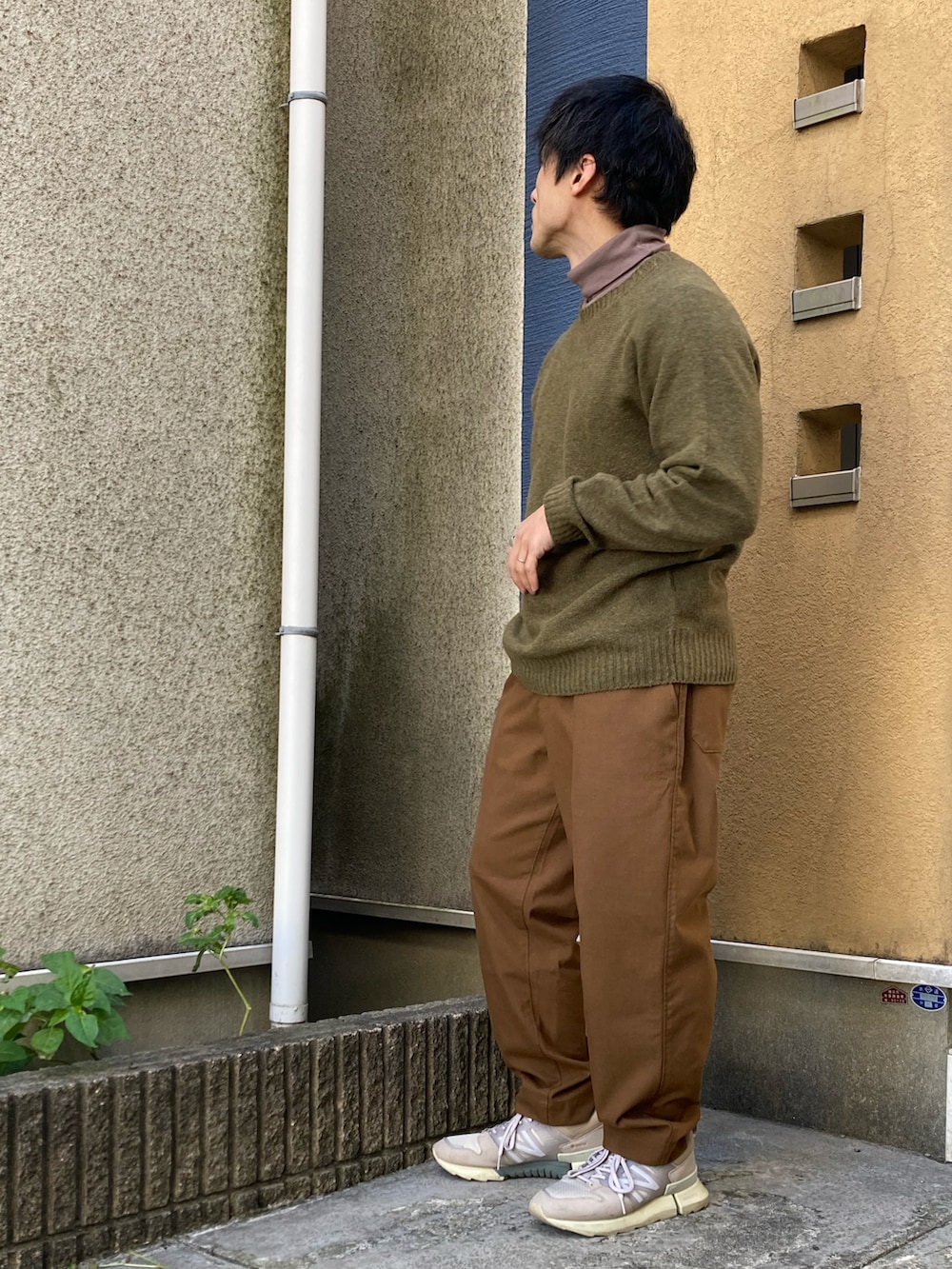 ブラウン系のパンツ、ブラウン系のTシャツ/カットソー、ホワイト系のブルゾンを着用したメンズの冬コーディネートの3枚目の写真