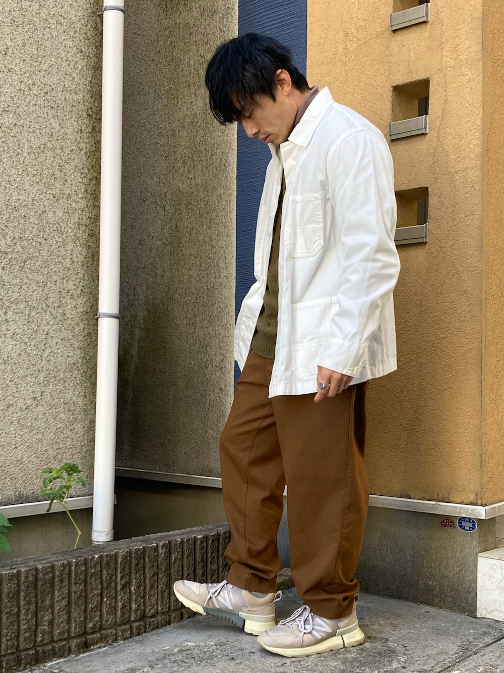 ブラウン系のパンツ、ブラウン系のTシャツ/カットソー、ホワイト系のブルゾンを着用したメンズの冬コーディネートの2枚目の写真