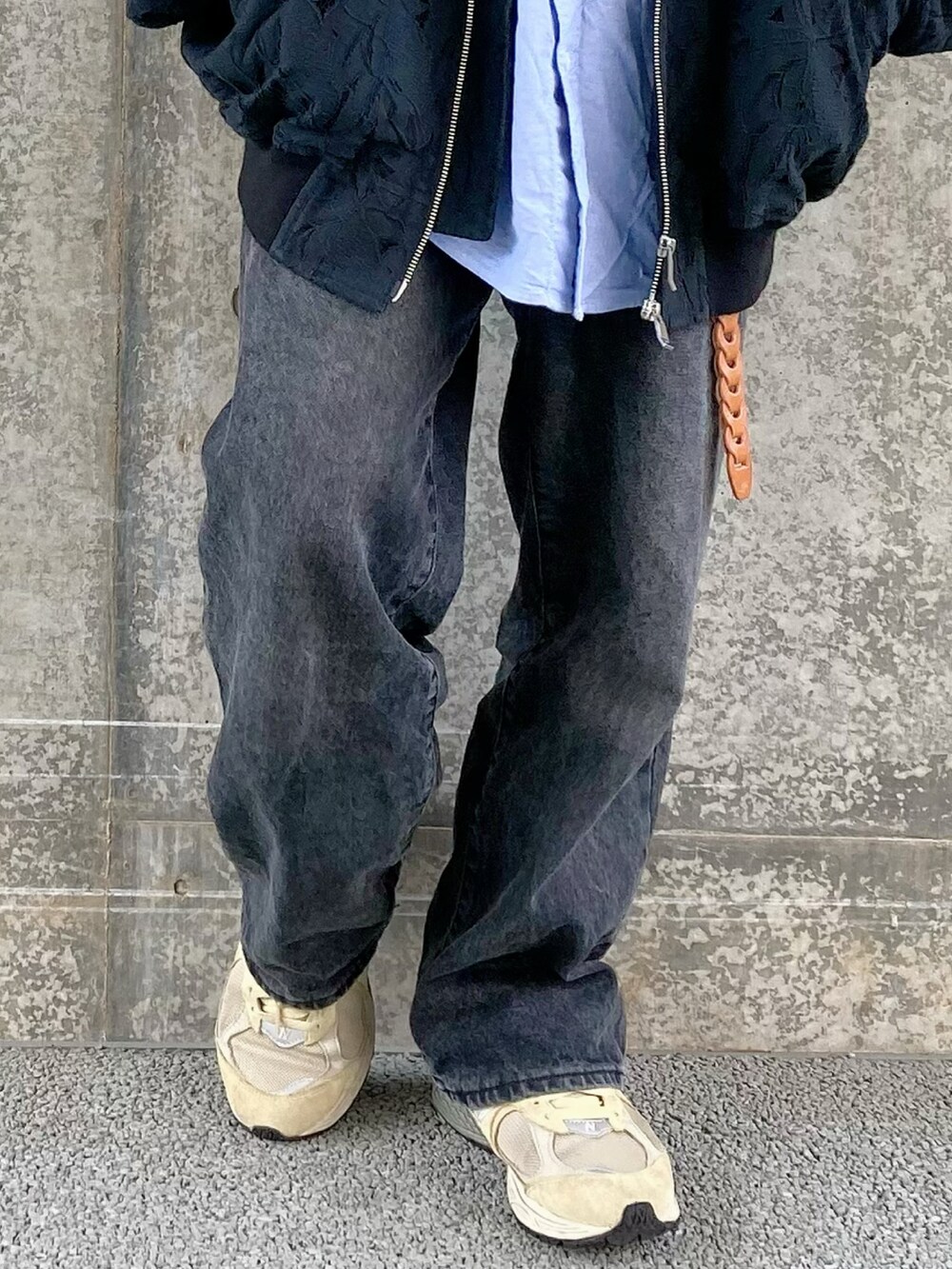 ブラック系のデニムパンツ、ベージュ系のスニーカー、ブラック系のブルゾンを着用したメンズの春コーディネートの4枚目の写真