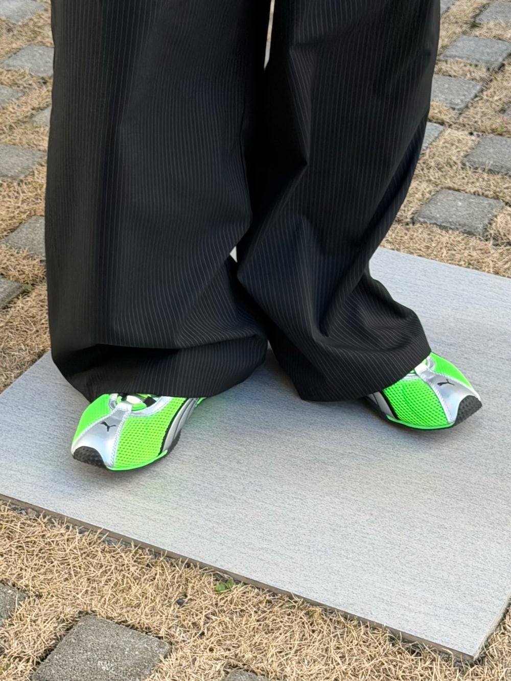 グリーン系のスニーカー、グリーン系のシャツ/ブラウス、ブラック系のブルゾンを着用したメンズの春コーディネートの2枚目の写真