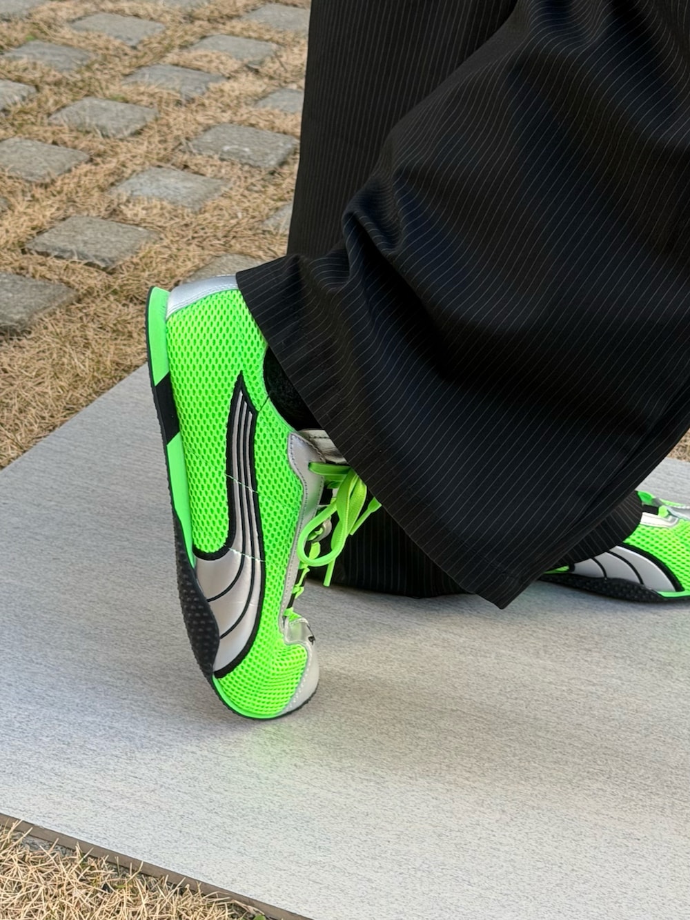 グリーン系のスニーカー、グリーン系のシャツ/ブラウス、ブラック系のブルゾンを着用したメンズの春コーディネートの3枚目の写真