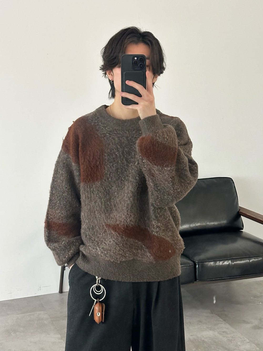 ブラウン系のニット/セーター、グレー系のスラックス、ブラック系のモカシン/デッキシューズを着用したメンズの冬コーディネートの2枚目の写真