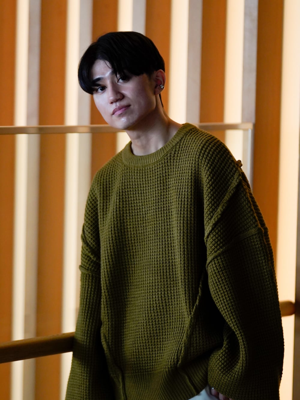 グリーン系のニット/セーター、ホワイト系のパンツ、ブラック系のドレスシューズを着用したメンズの秋コーディネートの2枚目の写真