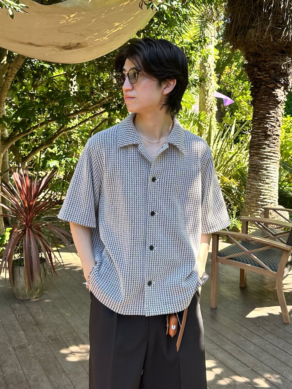 ホワイト系のシャツ/ブラウス、ブラック系のスラックス、ブラック系のサンダルを着用したメンズの夏コーディネートの2枚目の写真