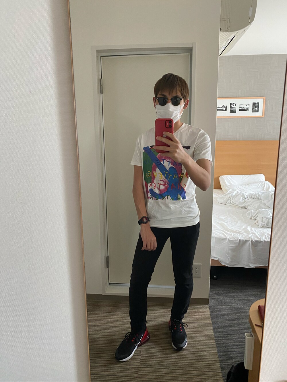 ブラック系のデニムパンツ、ブラック系のスニーカー、ホワイト系のTシャツ/カットソーを着用したメンズの春コーディネートの2枚目の写真