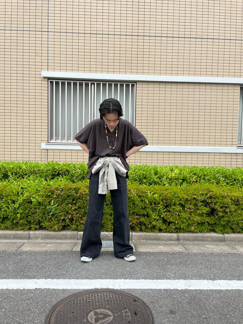 ブラック系のデニムパンツ、ブラウン系のTシャツ/カットソーを着用したメンズの夏コーディネートの2枚目の写真