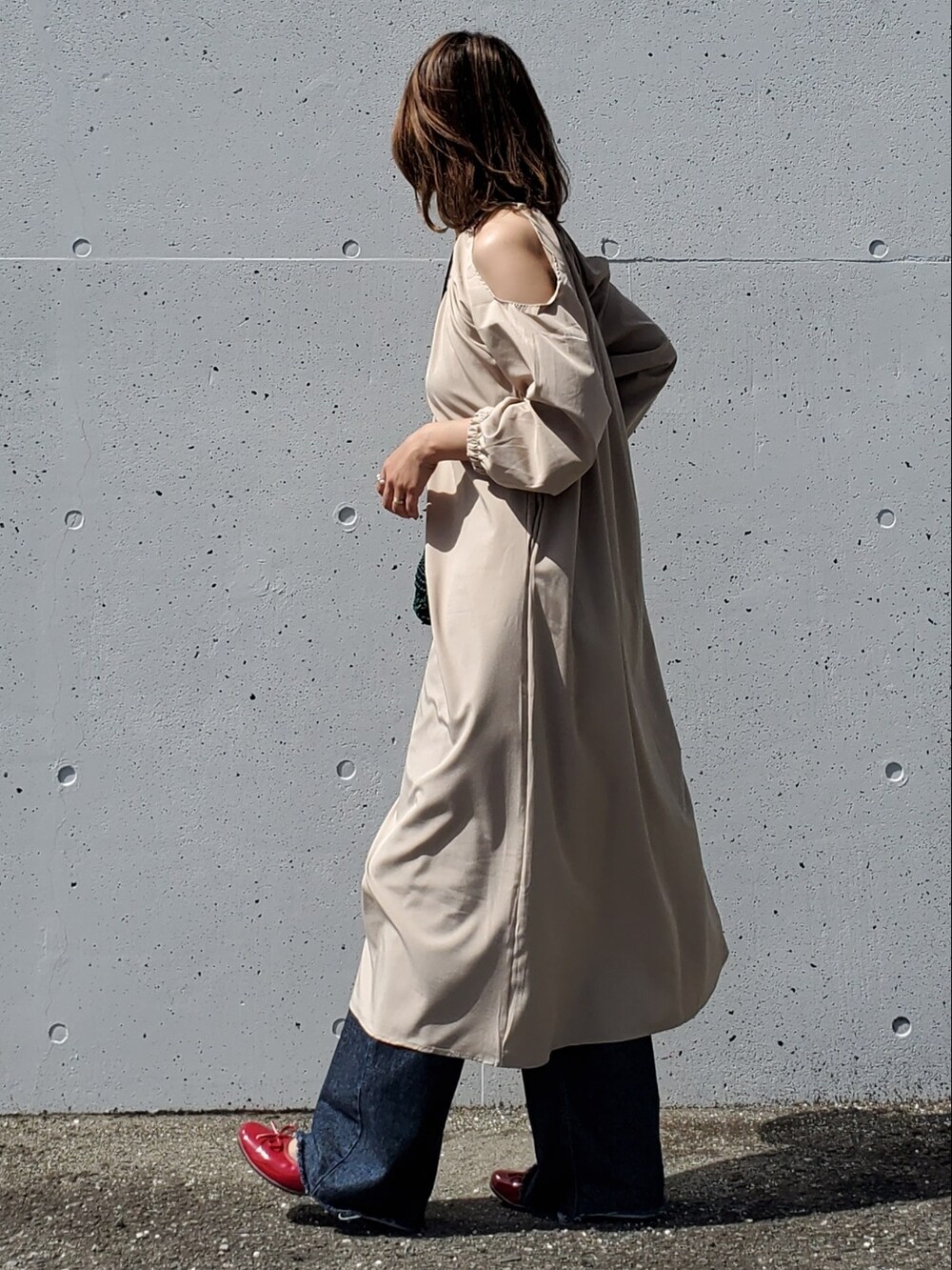 ベージュ系のワンピース、ブルー系のデニムパンツ、レッド系のバレエシューズを着用したレディースの春コーディネートの3枚目の写真