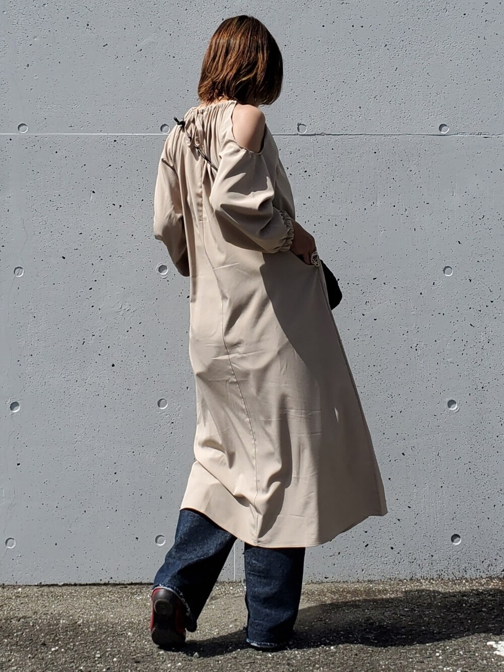 ベージュ系のワンピース、ブルー系のデニムパンツ、レッド系のバレエシューズを着用したレディースの春コーディネートの4枚目の写真