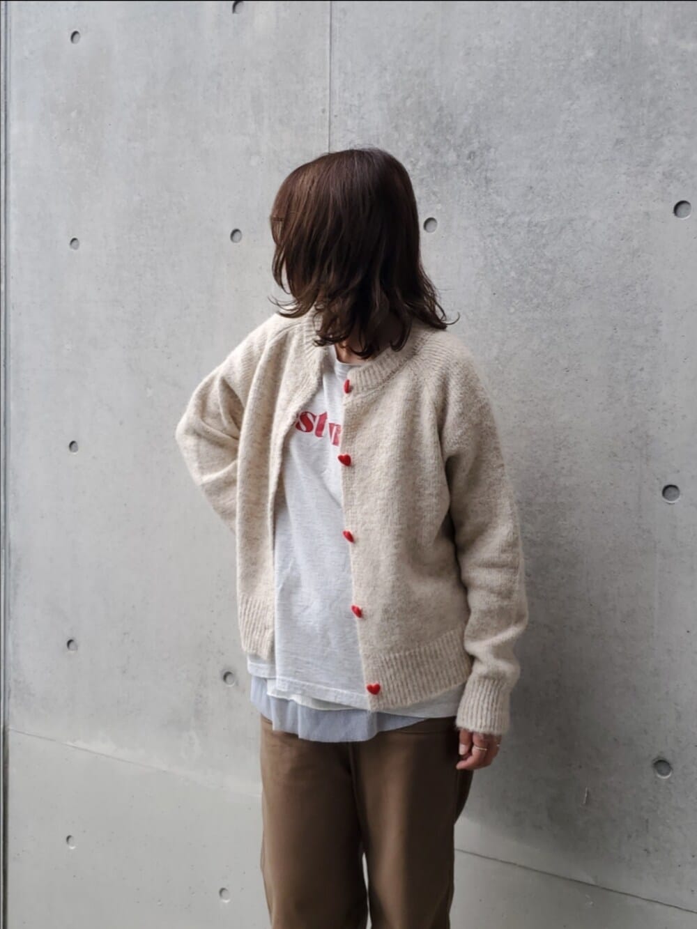 ブラック系のシューズ、ブラウン系のチノパンツ、ホワイト系のTシャツ/カットソーを着用したレディースの秋コーディネートの2枚目の写真