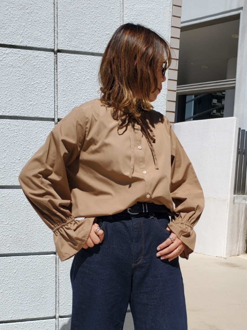 ブルー系のデニムパンツ、ベージュ系のシャツ/ブラウス、レッド系のバレエシューズを着用したレディースの秋コーディネートの2枚目の写真