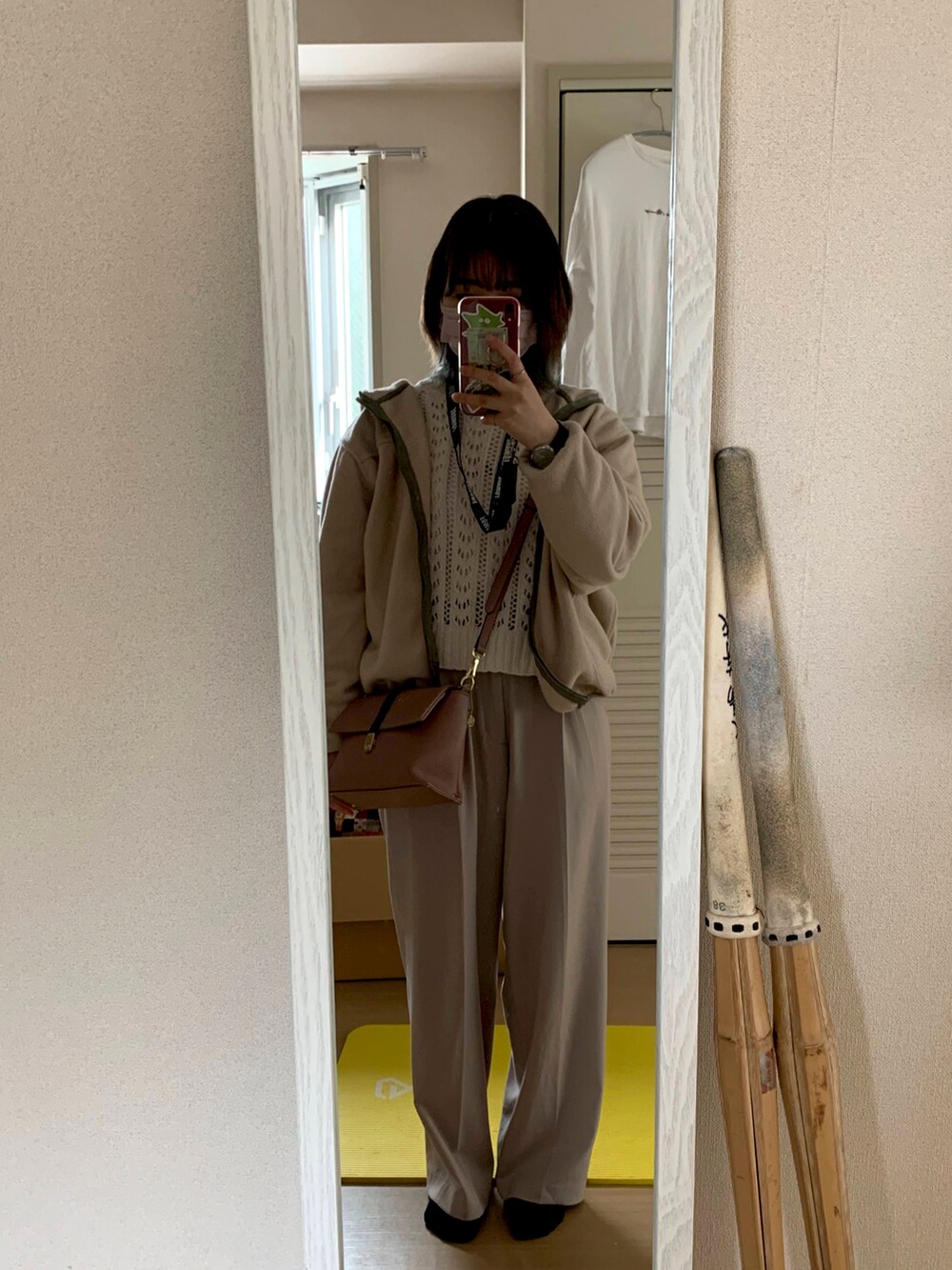 グレー系のスラックス、ピンク系のショルダーバッグ、ブラック系のスニーカーを着用したレディースの春コーディネートの2枚目の写真