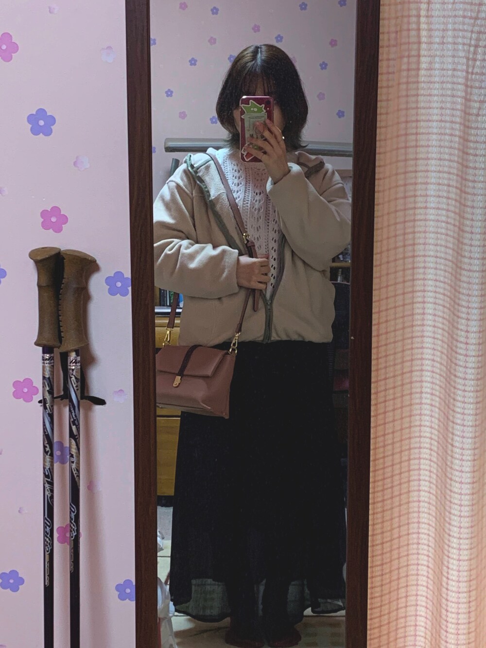 ブラック系のスカート、ホワイト系のTシャツ/カットソー、ホワイト系のニット/セーターを着用したレディースの春コーディネートの2枚目の写真