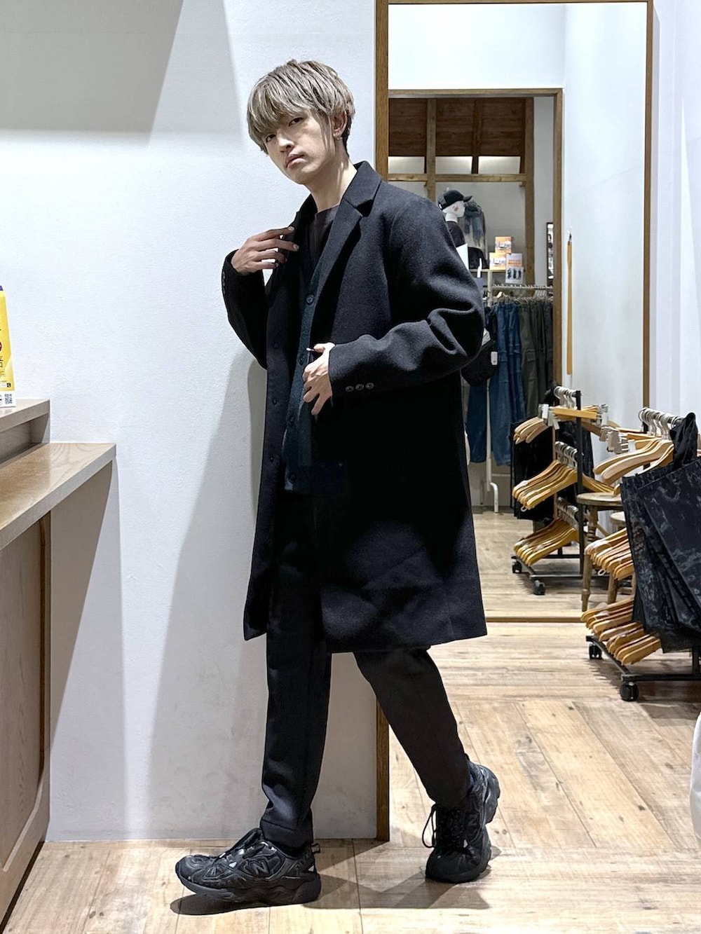 ブラック系のチェスターコート、ブラック系のその他パンツ、グリーン系のカーディガン/ボレロを着用したメンズの冬コーディネートの2枚目の写真