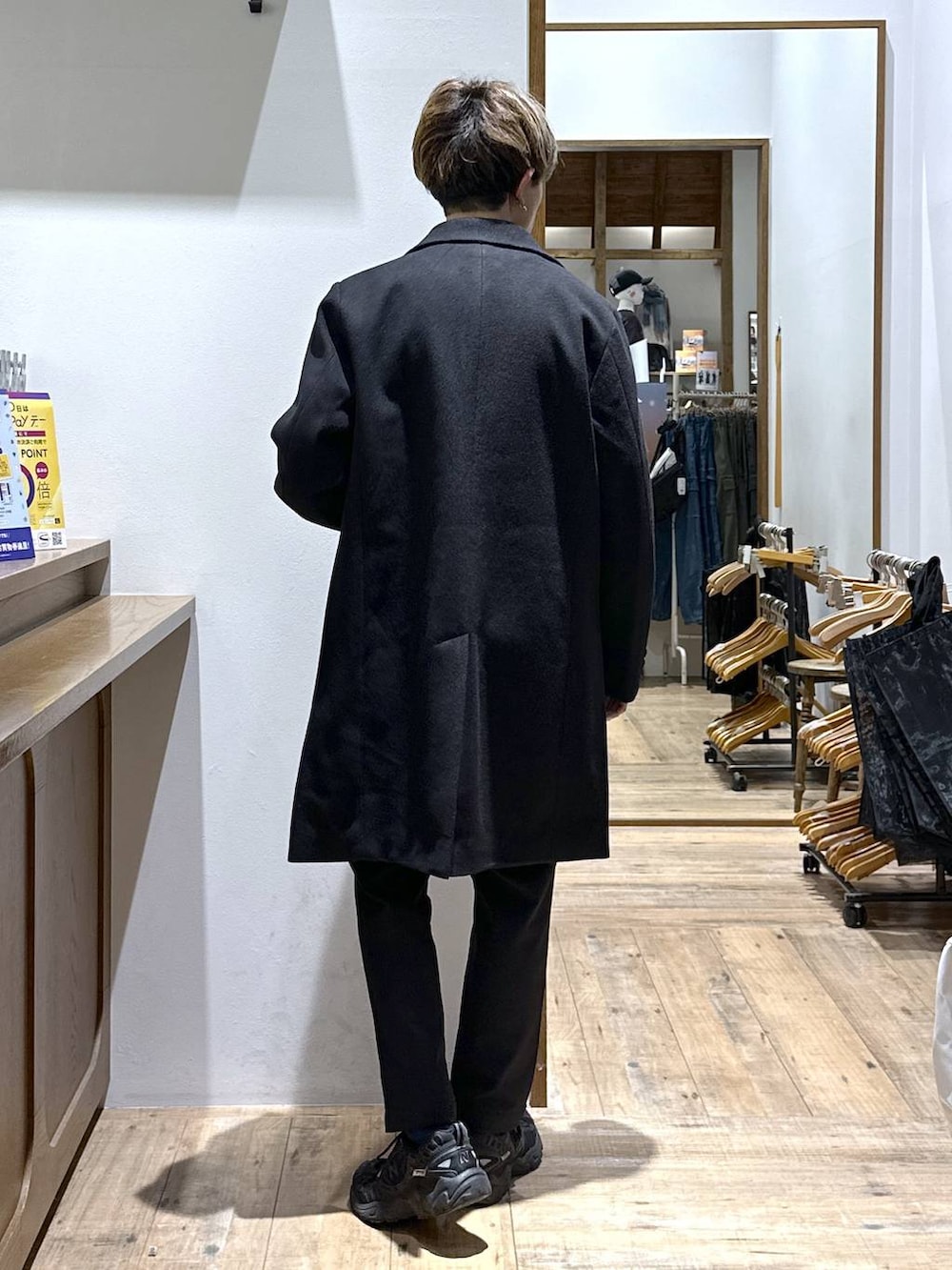 ブラック系のチェスターコート、ブラック系のその他パンツ、グリーン系のカーディガン/ボレロを着用したメンズの冬コーディネートの3枚目の写真