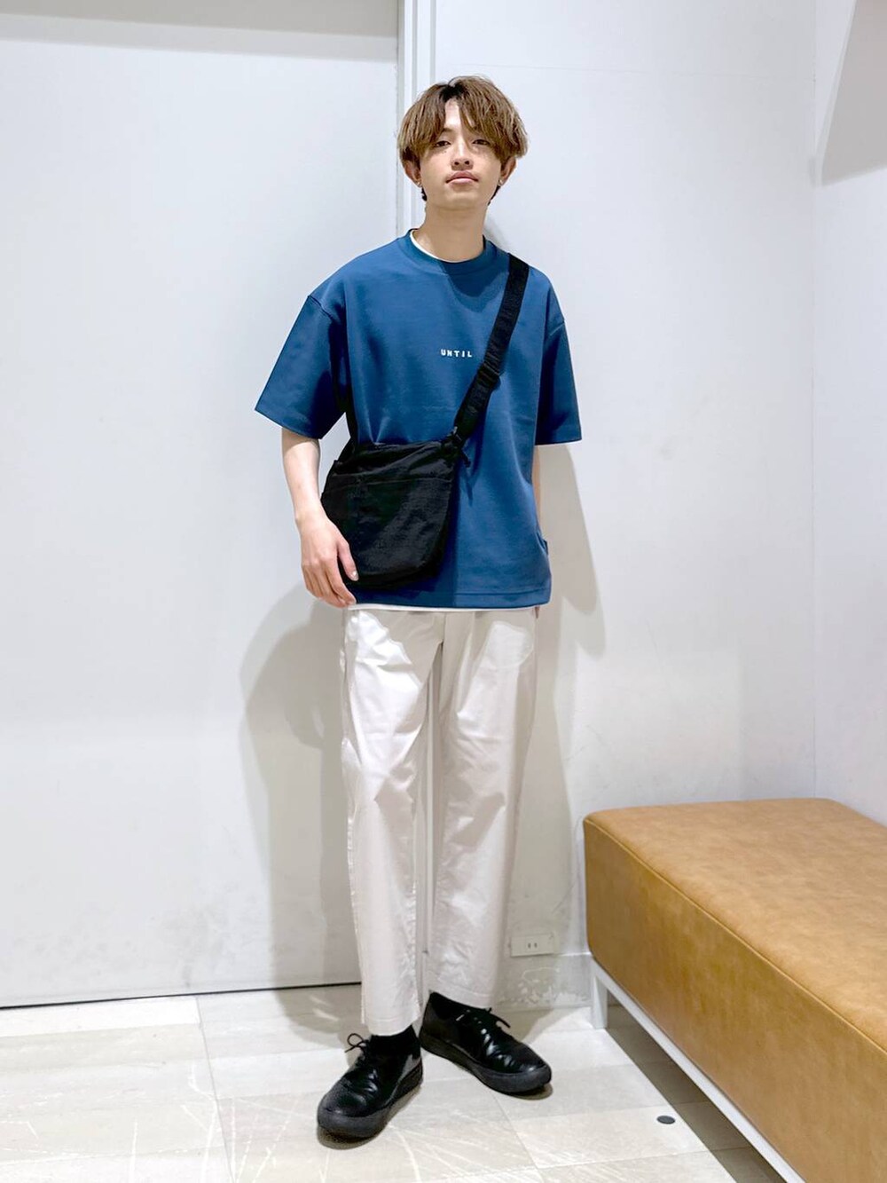 ブラック系のショルダーバッグ、ホワイト系のその他パンツ、ブルー系のTシャツ/カットソーを着用したメンズの春コーディネートの2枚目の写真