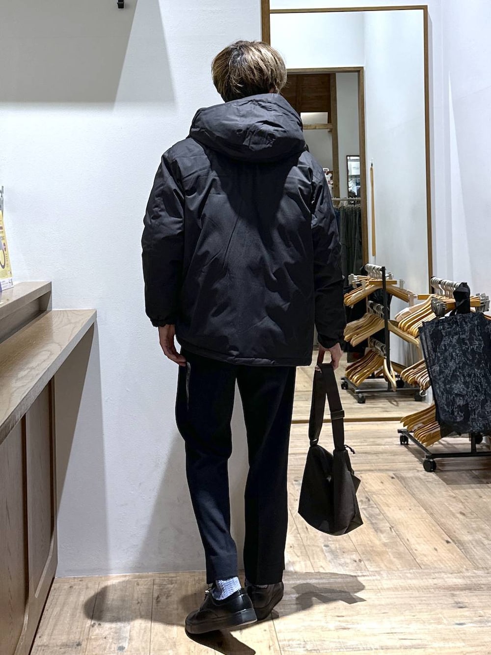 ブラック系のダウンジャケット/コート、ブルー系のスラックス、レッド系のニット/セーターを着用したメンズの冬コーディネートの3枚目の写真