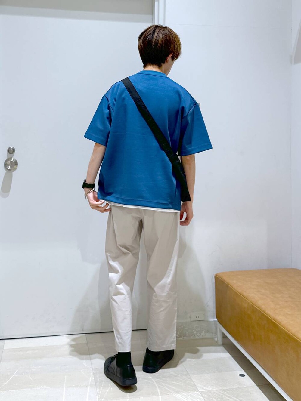 ブラック系のショルダーバッグ、ホワイト系のその他パンツ、ブルー系のTシャツ/カットソーを着用したメンズの春コーディネートの3枚目の写真