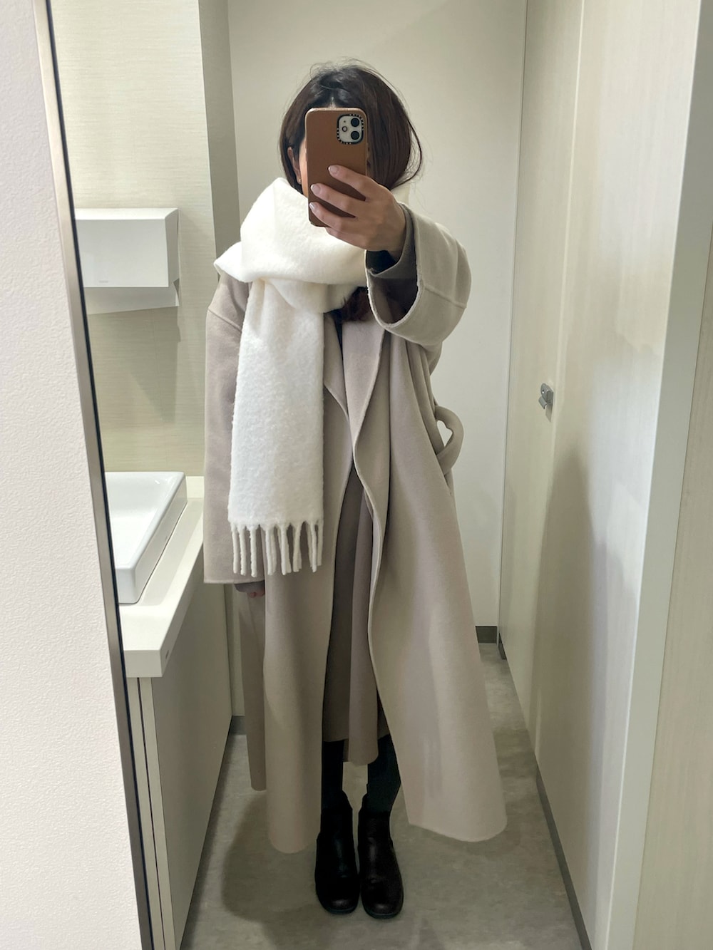 ベージュ系のその他アウター、ホワイト系のマフラーを着用したレディースの冬コーディネートの2枚目の写真