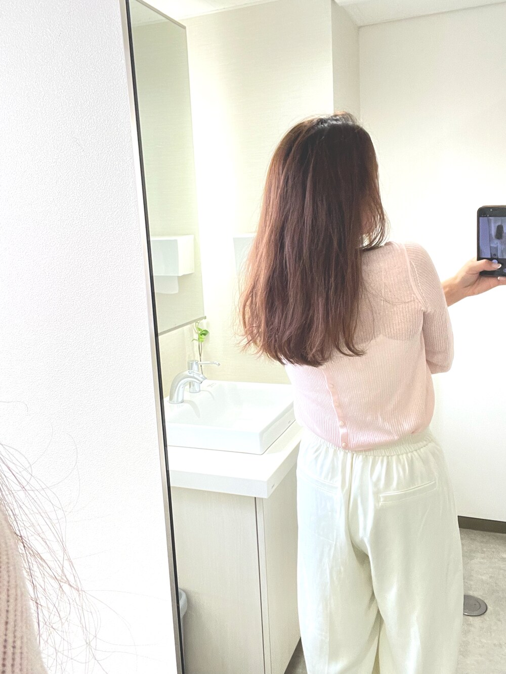 ピンク系のニット/セーターを着用したレディースの夏コーディネートの2枚目の写真