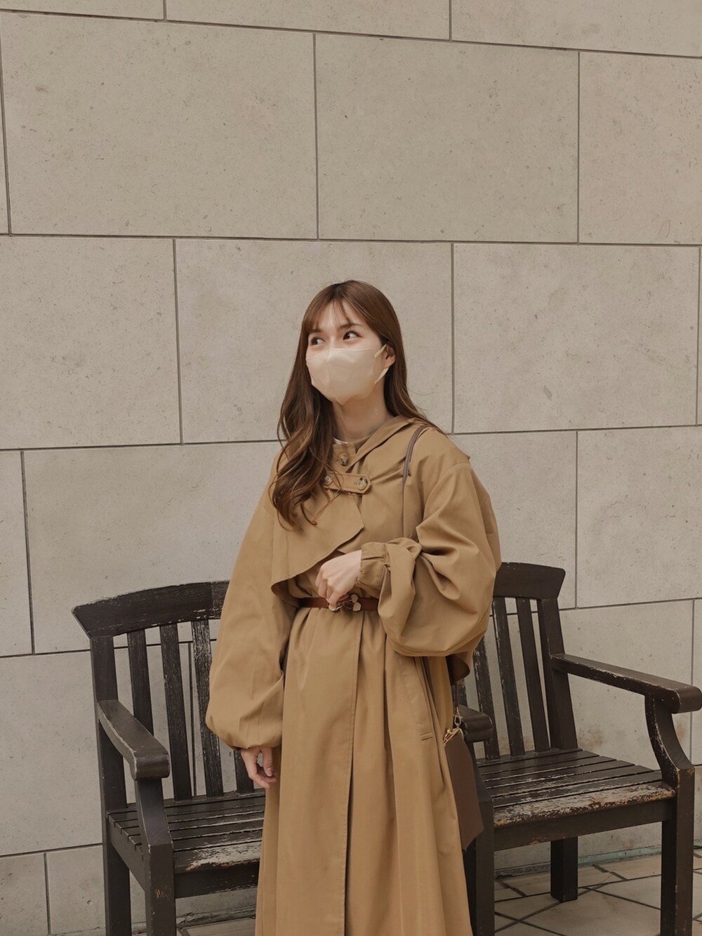 ベージュ系のトレンチコート、ブラウン系のショルダーバッグ、ブラウン系のベルトを着用したレディースの春コーディネートの2枚目の写真