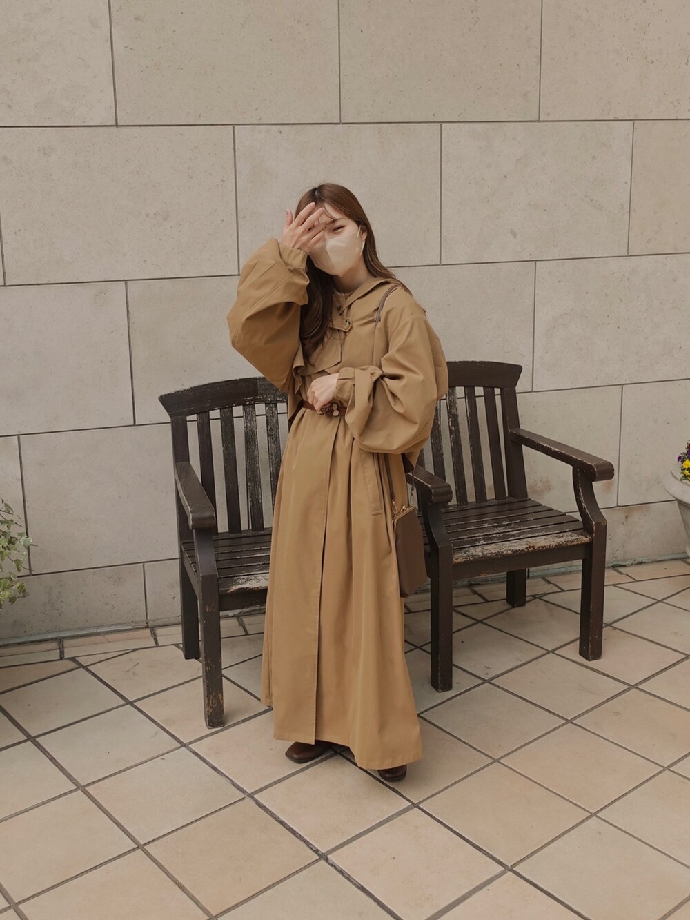 ベージュ系のトレンチコート、ブラウン系のショルダーバッグ、ブラウン系のベルトを着用したレディースの春コーディネートの3枚目の写真