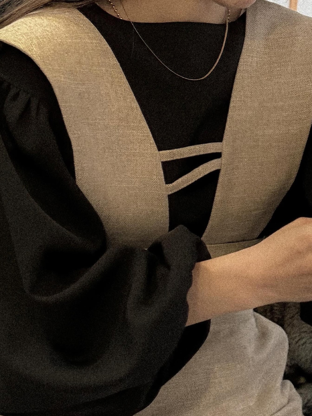 ベージュ系のジャンパースカート、ブラック系のシャツ/ブラウス、ブラック系のショルダーバッグを着用したレディースの冬コーディネートの2枚目の写真