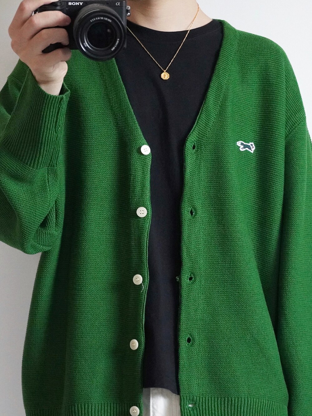 グリーン系のカーディガン/ボレロ、ブラック系のTシャツ/カットソー、ホワイト系のデニムパンツを着用したメンズの秋コーディネートの2枚目の写真