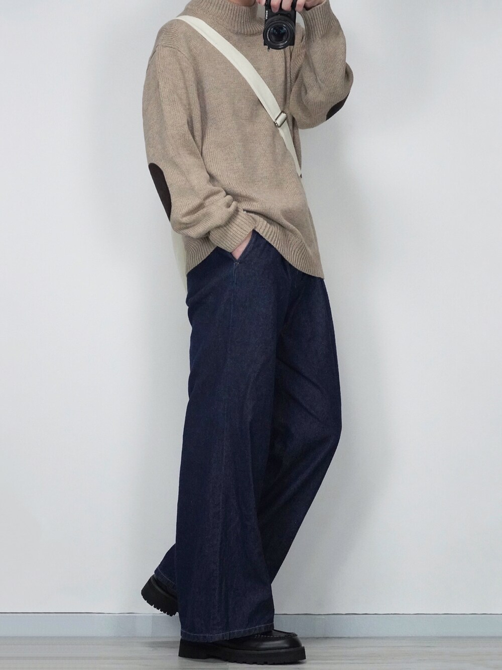 ベージュ系のシャツ/ブラウス、ベージュ系のニット/セーター、ブルー系のデニムパンツを着用したメンズの秋コーディネートの2枚目の写真