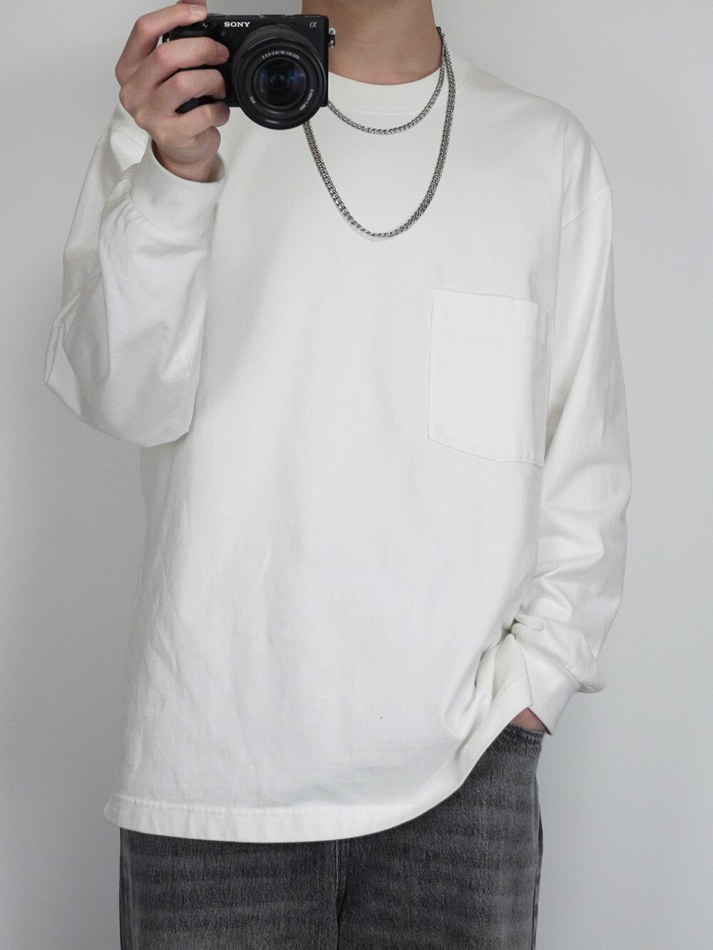 ブラック系のその他アウター、ホワイト系のTシャツ/カットソー、グレー系のデニムパンツを着用したメンズの秋コーディネートの2枚目の写真