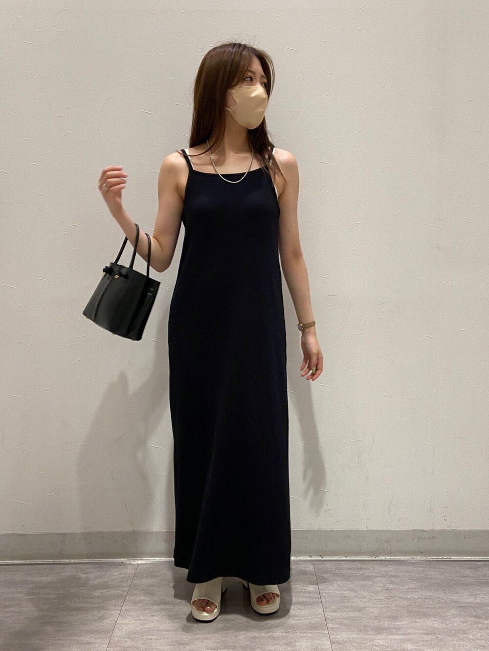 ブラック系のバッグ、ホワイト系のサンダル、ブラック系のワンピースを着用したレディースの春コーディネートの4枚目の写真