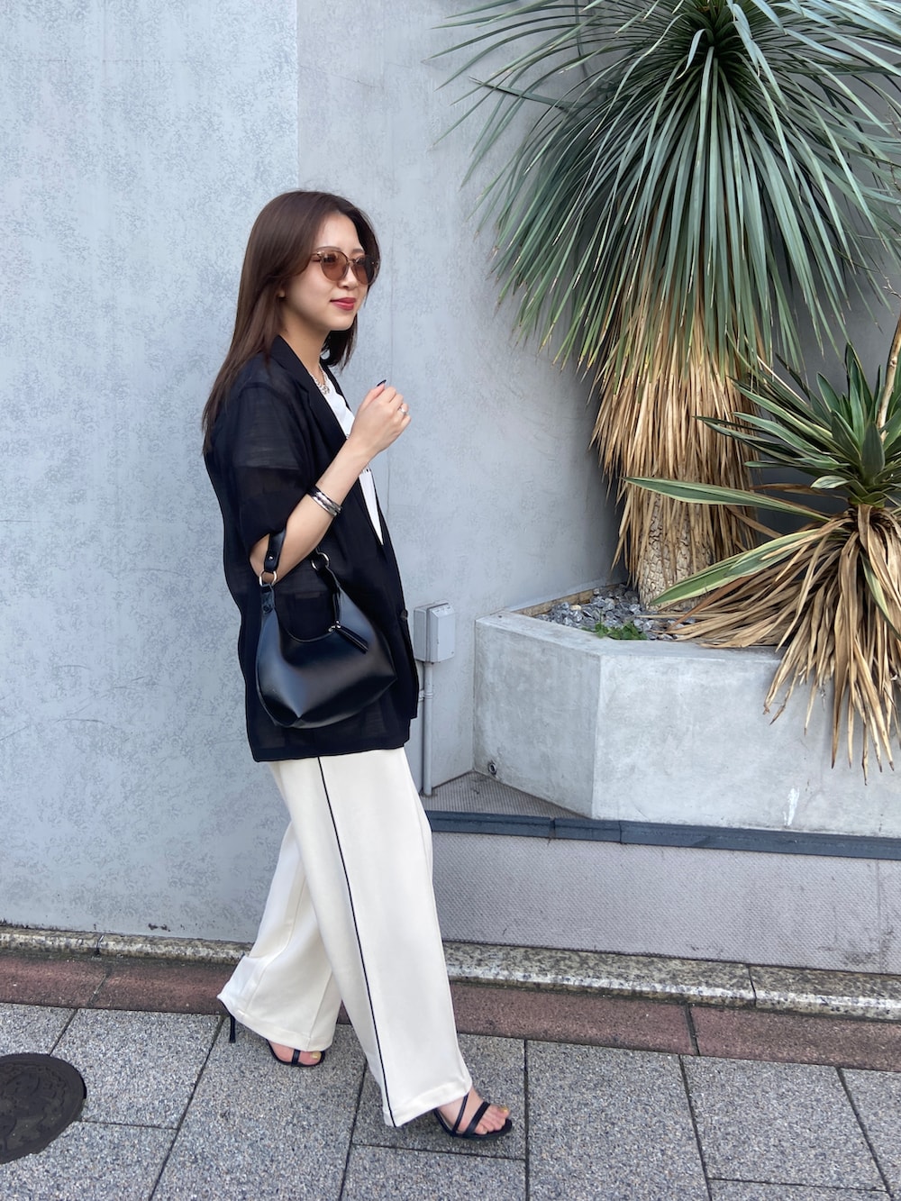 ブラック系のショルダーバッグ、ホワイト系のその他パンツ、ホワイト系のTシャツ/カットソーを着用したレディースの夏コーディネートの2枚目の写真