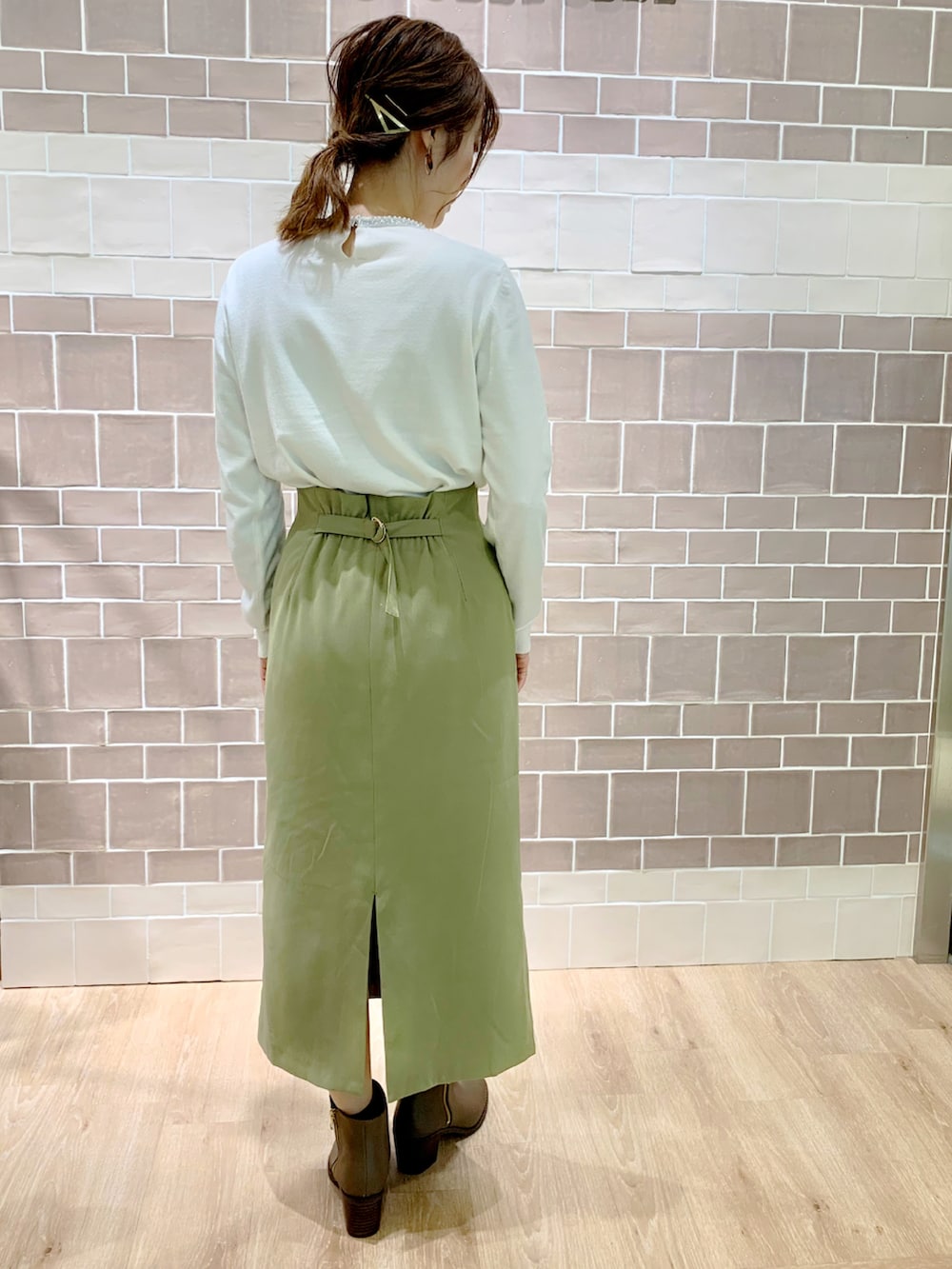 グリーン系のスカート、ベージュ系のノーカラーコート、ベージュ系のブーツを着用したレディースの冬コーディネートの5枚目の写真