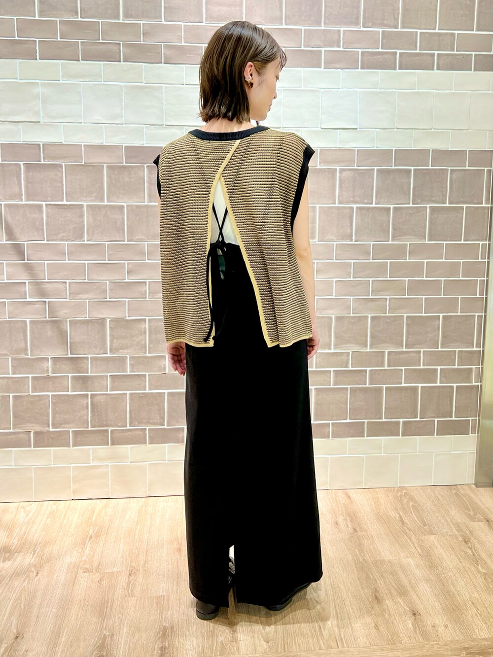 ブラック系のローファー、ブラック系のワンピース、ブラック系のベストを着用したレディースの夏コーディネートの2枚目の写真