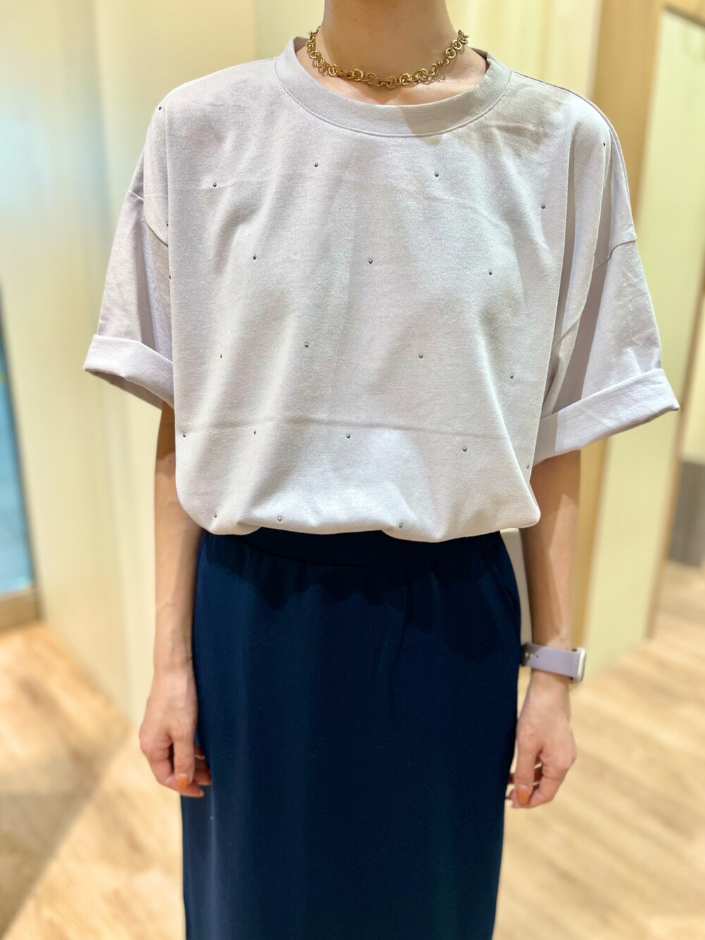 グレー系のTシャツ/カットソー、ブルー系のスカート、グレー系のスニーカーを着用したレディースの秋コーディネートの2枚目の写真