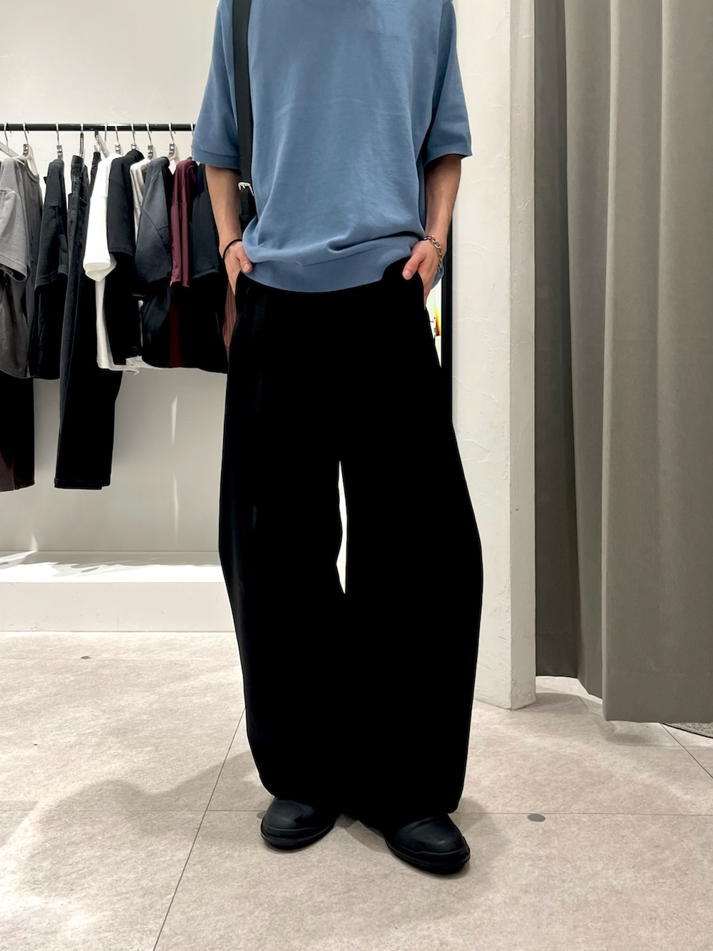 ブルー系のTシャツ/カットソー、ブラック系のスラックス、ブラック系のショルダーバッグを着用したメンズの夏コーディネートの3枚目の写真