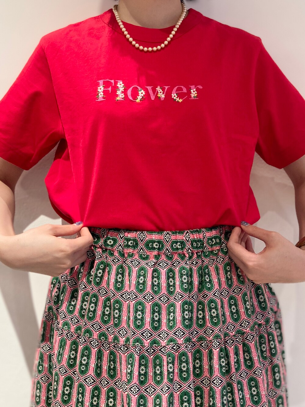 レッド系のTシャツ/カットソー、ピンク系のスカートを着用したレディースの春コーディネートの4枚目の写真