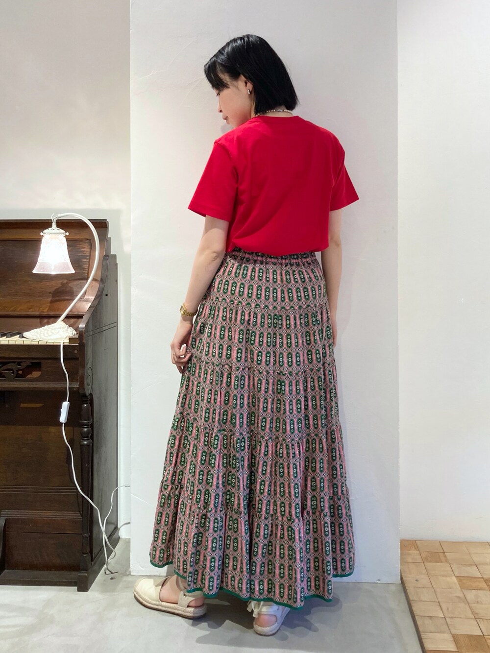 レッド系のTシャツ/カットソー、ピンク系のスカートを着用したレディースの春コーディネートの2枚目の写真