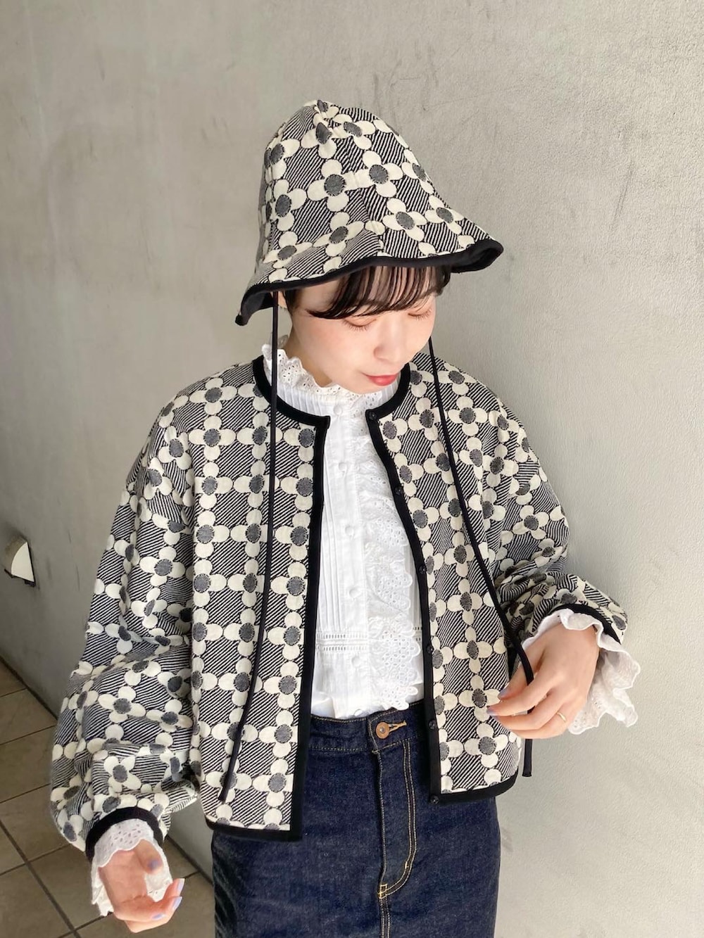 ブルー系のデニムスカート、ブラック系のカーディガン/ボレロ、ホワイト系のシャツ/ブラウスを着用したレディースの冬コーディネートの3枚目の写真